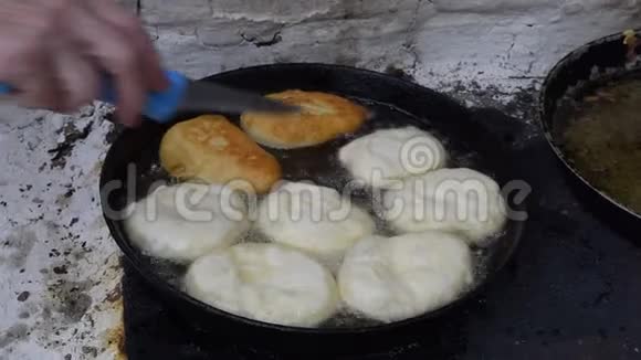 在炉子上的煎锅里用油煎饼烹饪馅饼的传统视频的预览图