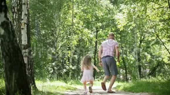快乐的家庭男人和他的女儿在夏季公园慢动作视频的预览图