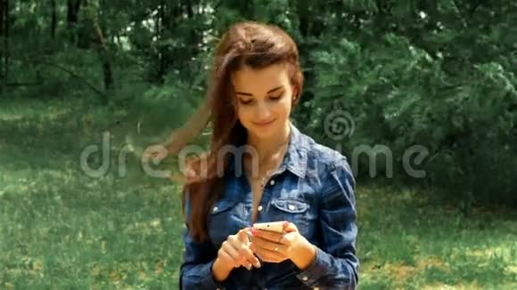 漂亮的黑发女人坐在街上看着电话视频的预览图