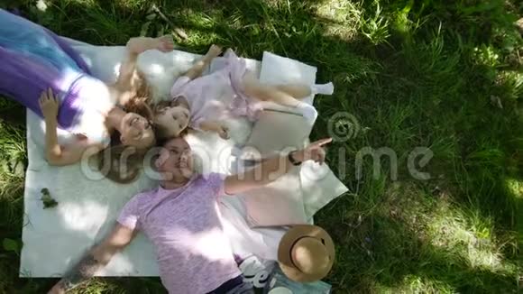 一家人在公园里休息爸爸妈妈和女儿吃早餐俯视图视频的预览图