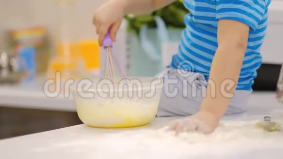 小男孩在桌子上准备面团打喷嚏小宝宝玩面粉面包师准备面团视频的预览图