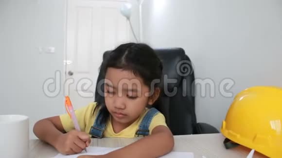 DollySlel亚洲小女孩用白纸画黄色工程师帽视频的预览图
