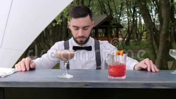 酒吧后的肖像酒保酒吧服务员提交酒精酒吧服务员特写酒吧柜台彩色冰镇饮料视频的预览图