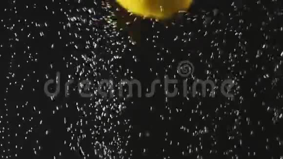 新鲜柠檬掉进水里黑色背景上有气泡水中的新鲜浆果有机浆果水果视频的预览图