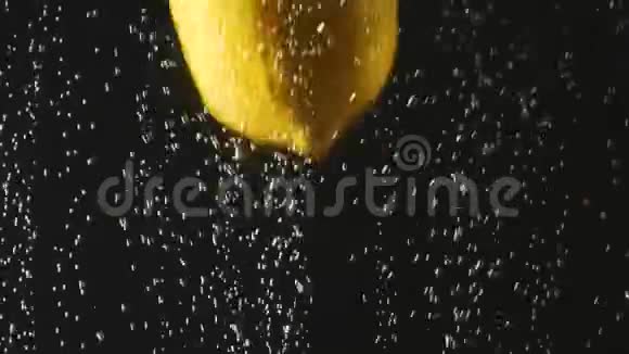 新鲜柠檬掉进水里黑色背景上有气泡水中的新鲜浆果有机浆果水果视频的预览图