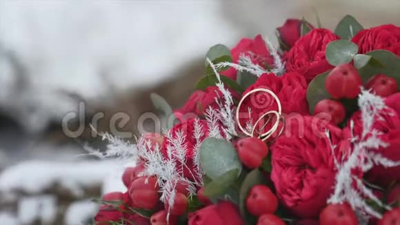 婚礼花束与结婚戒指与红色的花朵背景雪视频的预览图