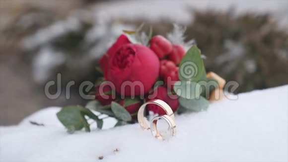 婚礼花束与结婚戒指与红色的花朵背景雪视频的预览图
