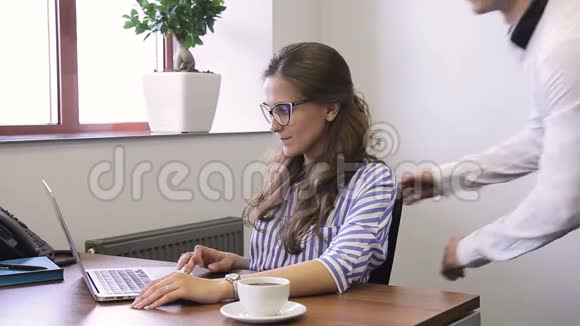 年轻的经理在现代办公室工作看着笔记本电脑屏幕说话视频的预览图