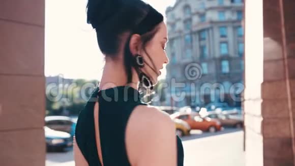 一位身着优雅服装的黑发女子走出大楼后转向镜头分享一种诱惑视频的预览图