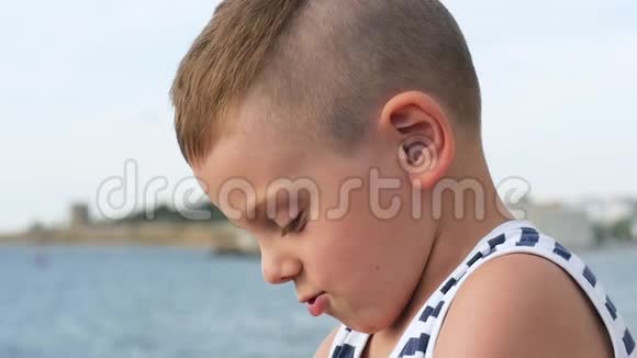 穿着水手条纹背心的小男孩在天空和大海的背景下视频的预览图