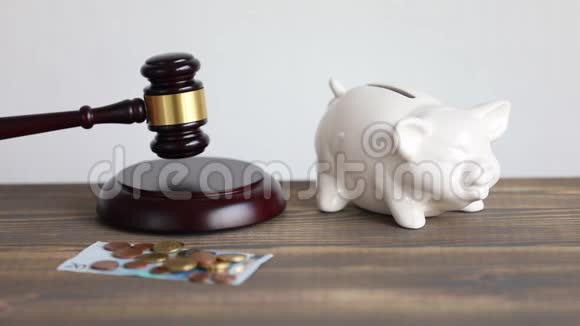 金钱与正义观念鞭笞法官锤桌上有欧元硬币和储蓄罐视频的预览图