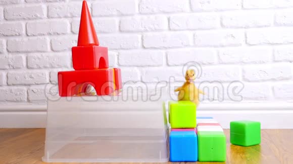 小黄鸭走在孩子们身上彩色立方体在室内在白色的背景上视频的预览图