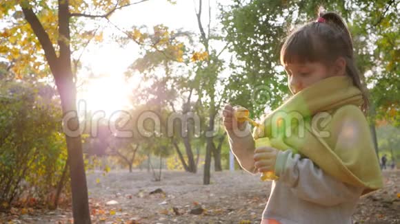 快乐的孩子在公园的阳光下玩肥皂泡视频的预览图