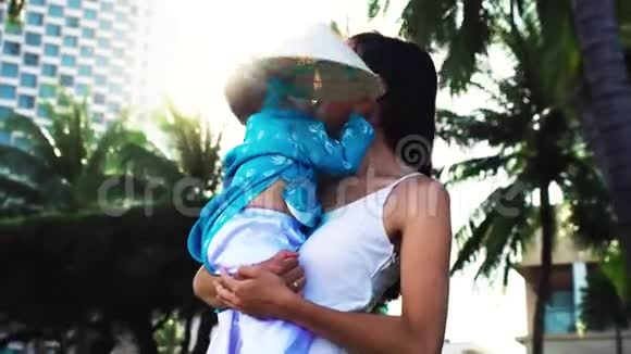 一位母亲把她的小女儿抱在手心附近的海滩上视频的预览图