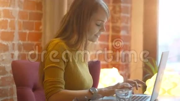 小女孩在咖啡馆里用笔记本电脑打视频电话视频的预览图