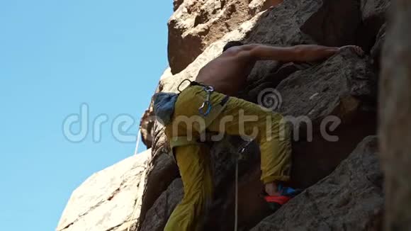 运动员攀岩者爬在悬崖上伸手抓住视频的预览图