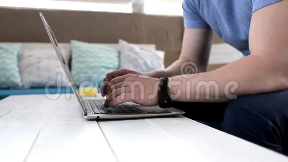 在咖啡馆里用笔记本电脑打字的人视频的预览图
