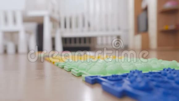 幼儿园里的一个小孩赤脚走在按摩垫上踩在一个带刺的表面上视频的预览图
