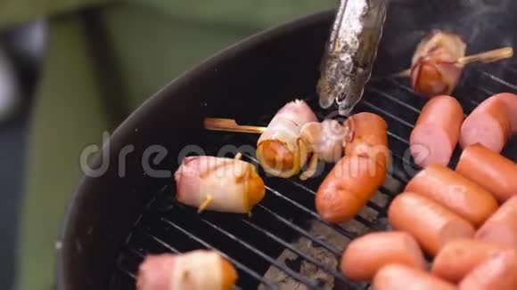 裹着熏肉的香肠在托盘上煎熏肉烧烤的香肠视频的预览图