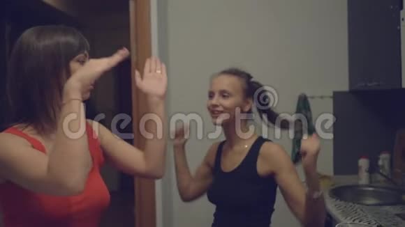 两个年轻的女人正在家里的厨房里跳舞视频的预览图