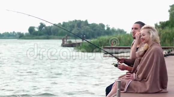 男朋友和女朋友一起在河边钓鱼湖面上寒冷的早晨美丽的风景视频的预览图