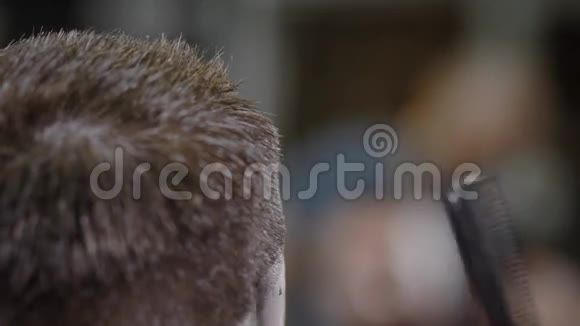 理发师用一把梳子帮你做一个发型这是一个用剪发器修剪头发的过程视频的预览图