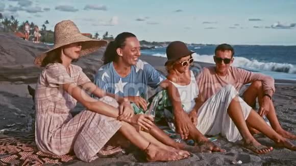 年轻人在海滩上玩得很开心在岛上度周末朋友们围着吉他快乐地唱歌视频的预览图
