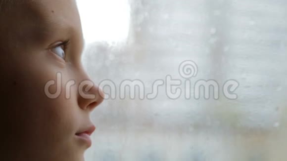 伤心的男孩在雨天看窗外视频的预览图