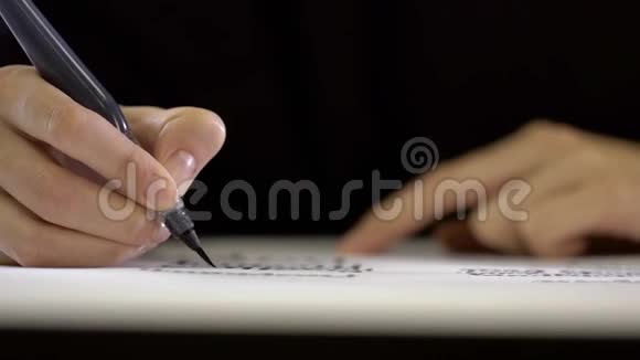 女手用毛笔字写在白纸上视频的预览图