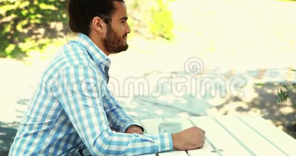 男子在4k室外餐厅喝咖啡视频的预览图