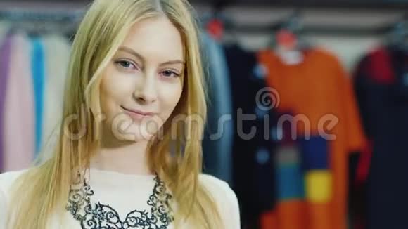 年轻女子模特的肖像看着一家服装店她微笑着看着摄像机视频的预览图
