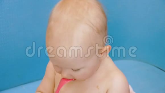 婴儿咬塑料勺子手拿着视频的预览图