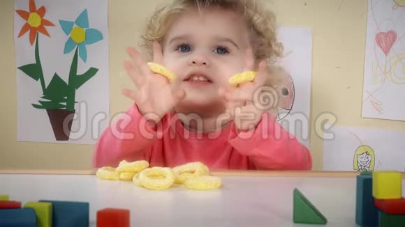饥肠辘辘的孩子坐在他房间的桌子旁吃玉米脆片视频的预览图