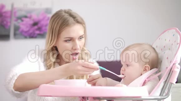 妈妈在婴儿椅上喂孩子女人给婴儿喂粥视频的预览图