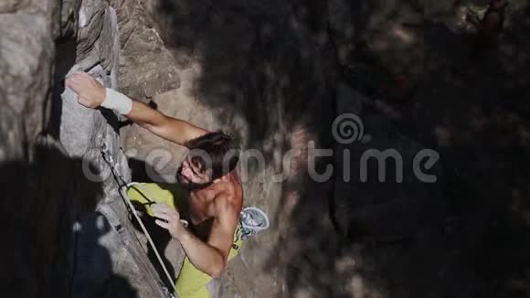 运动员攀岩者爬在悬崖上伸手抓住视频的预览图