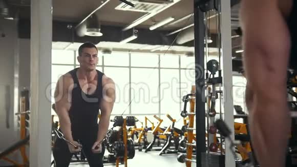 健美运动员在健身房的训练年轻肌肉男在镜子附近进行二头肌训练视频的预览图