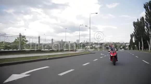 一个男人和一个女孩骑着一辆红色自行车沿着这条路骑视频的预览图
