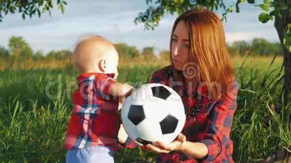 快乐的年轻母亲在阳光温暖的秋日或夏日与她的小儿子玩耍幸福的家庭观念视频的预览图