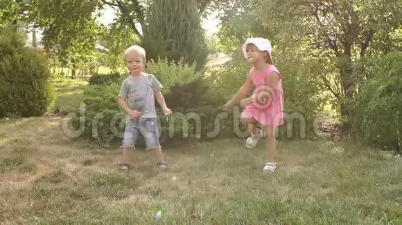 阳光公园里两个快乐的孩子的肖像视频的预览图