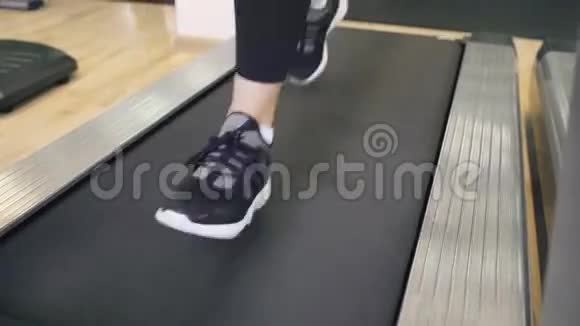 在健身房跑步机上穿运动鞋的女性脚的特写视频的预览图
