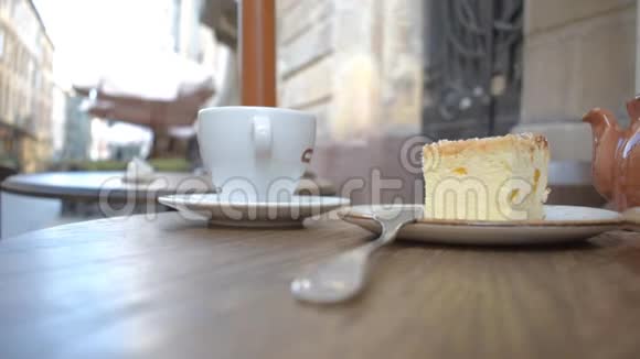 街边咖啡馆里有一杯咖啡和一个茶壶的美味甜点视频的预览图