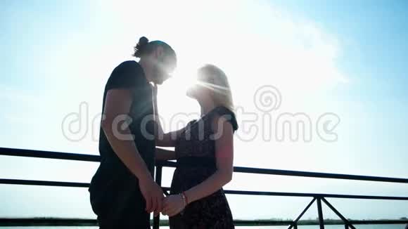 相爱的情侣在夕阳下接吻浪漫的情侣在阳光下牵手可爱的一对接吻视频的预览图