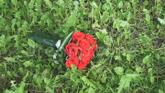 婚礼的玫瑰花束躺在草地上视频的预览图