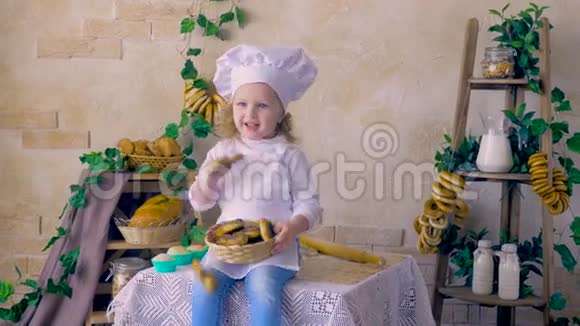 小女孩厨师扔松饼坐在厨房里视频的预览图