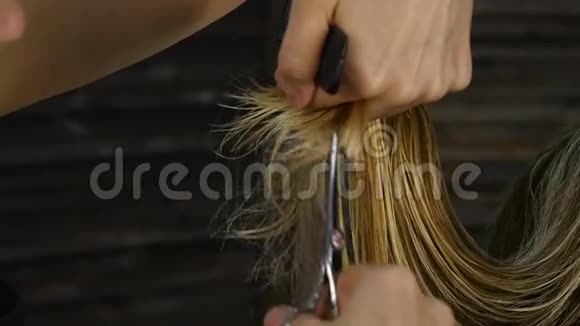 女理发师手牵着手指锁着头发用剪刀修剪头发的尖端视频的预览图