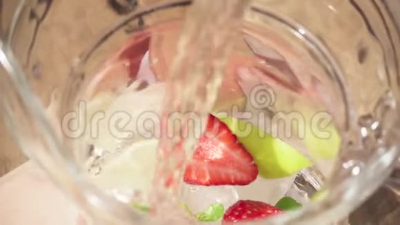 慢动作的水倒入盛有水果和冰的小瓶子里视频的预览图