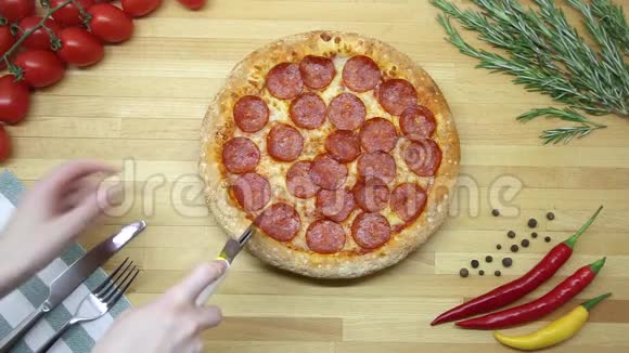 披萨女人的手在桌子上切披萨上景视频的预览图