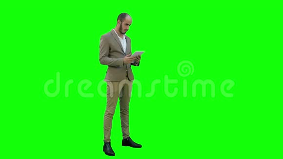 年轻经理通过平板电脑在绿色屏幕上举行视频会议Chroma键视频的预览图
