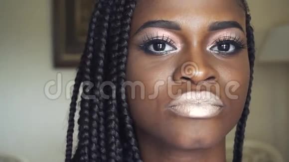 化妆师用辫子来弥补年轻漂亮的非裔美国模特极端特写视频的预览图