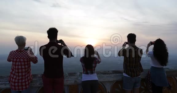 山顶上的人用手机拍照日出景观游客后视视频的预览图